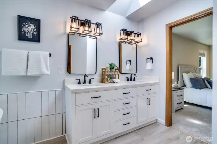 Dual vanities, quartz countertops, updated lighting, and abundant storage combine style with everyday functionality.
