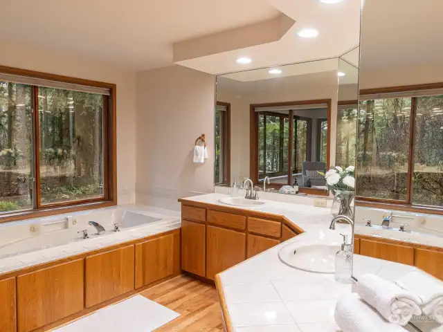 Primary suite 5-piece bathroom with jetted tub, large walk-in shower with two shower heads overlooking the private back yard.