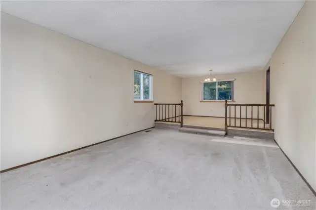 Carpeted family room leading to dining area.