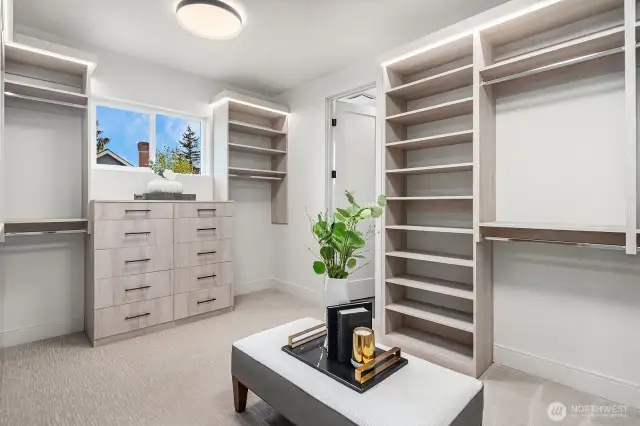 The Primary Bedroom closet is a masterfully designed space, featuring custom-built shelves and drawers for optimal organization. A charming clerestory window lets in an abundance of natural light, creating a bright and inviting atmosphere.