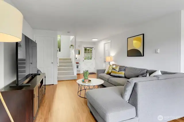 Looking toward the front door, the living room feels open and airy, highlighted by natural light.