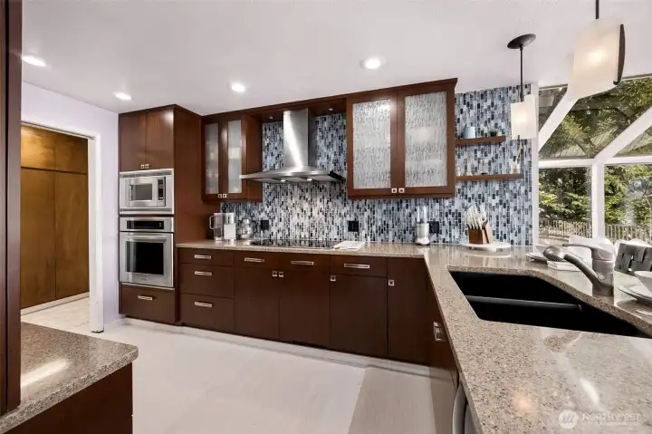 Stainless appliances and chef-style overhead venting, recessed lighting, and loads of storage between the kitchen and the pantry/utility space, all assist the cook with just the right of space in your kitchen work triangle.