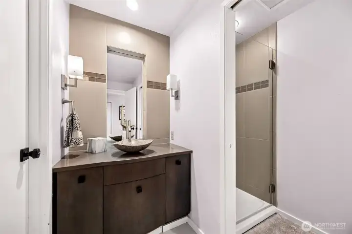 The main floor bath designed with dual entrances from the utility room and front hall that leads to the main floor bedroom, serves the purpose of day to day showering as you come off the beach and a handsome guest bath.