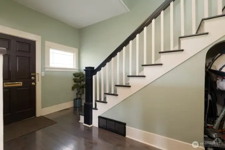 Inviting entry and beautifully detailed staircase set the tone for the home’s historic charm.