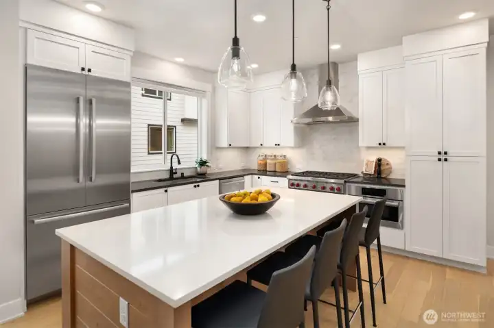 Premium kitchen with Wolf gas range, quartz island, and custom cabinetry.