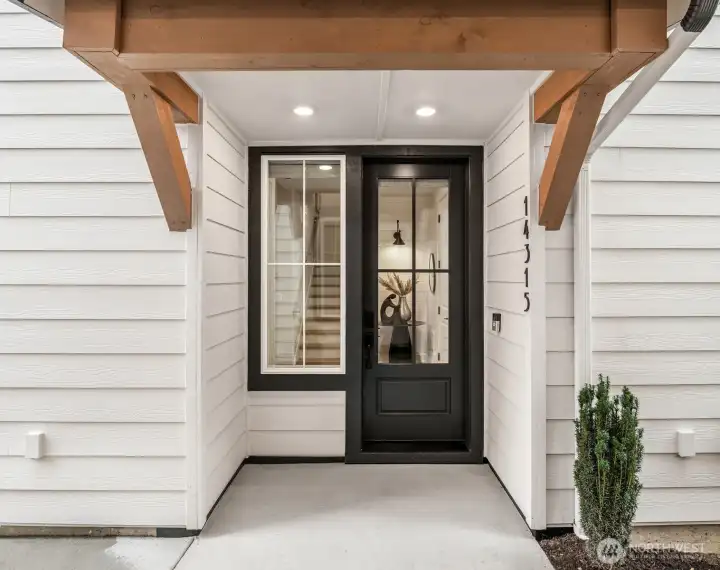 Covered front entry with modern farmhouse design and welcoming curb appeal.