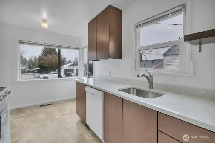 Newly remodeled eat-in kitchen with new stove and dishwasher.