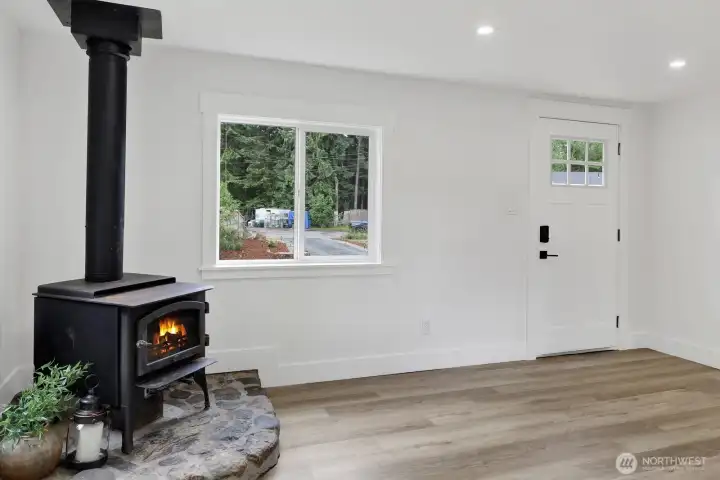 Imagine curling up with a good book or gathering with loved ones beside the efficient wood stove in this warm and welcoming living room, where comfort meets everyday living.