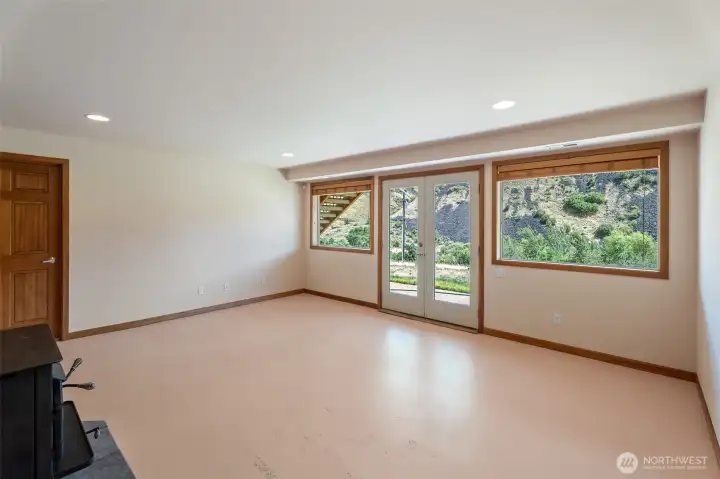 lower level great room, concrete floors and double doors to covered patio lower level great room, concrete floors and double doors to covered patio