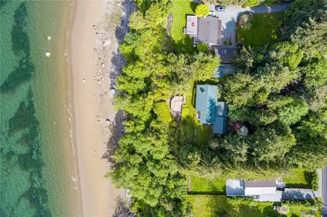 Expansive 154± feet of waterfront with lush greenery and direct beach access—an incredible island investment.