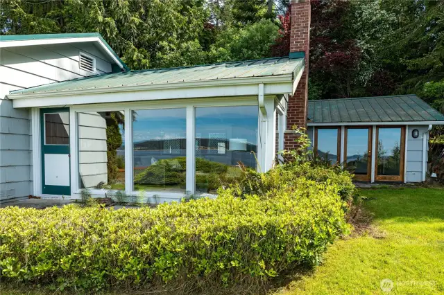 Charming beach cabin with metal roof, vaulted ceilings, and panoramic views.