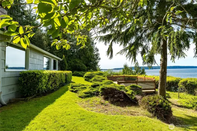 Sprawling lawn and lush landscaping lead to panoramic water views—nature and privacy in perfect harmony.