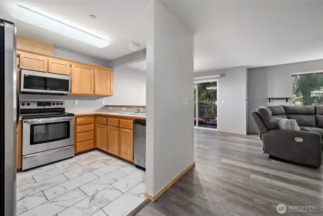 Kitchen with stainless appliances, brand new microwave and new tile floors.