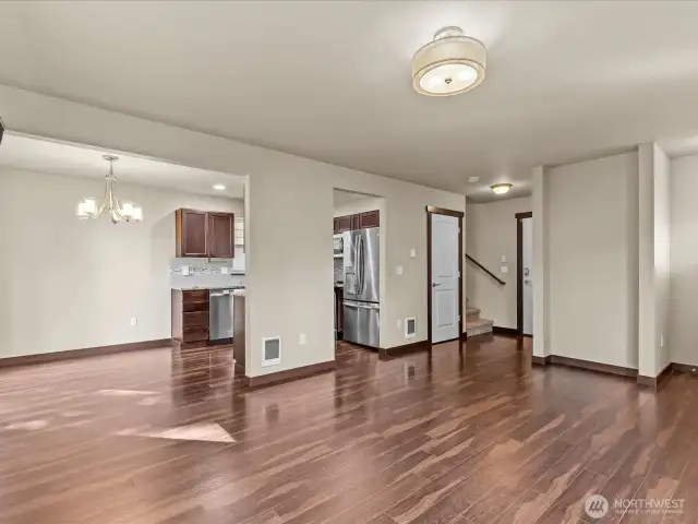 Great room showing dining & stairs by garage entry