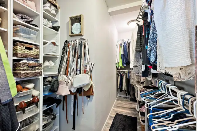Walk in closet with built-in shelves for organization.
