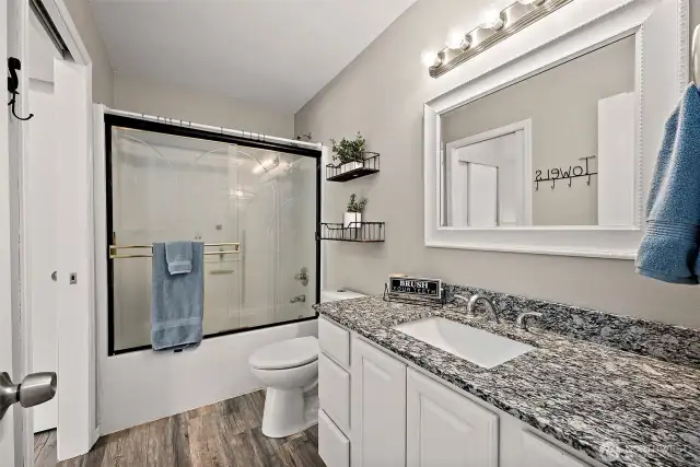 Main full bath with granite countertop.
