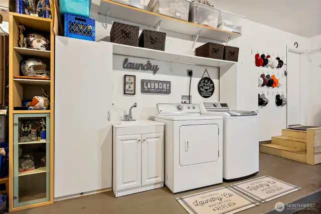 Organized laundry station.  Full size washer and dryer are included.  The white storage cabinets are also staying.
