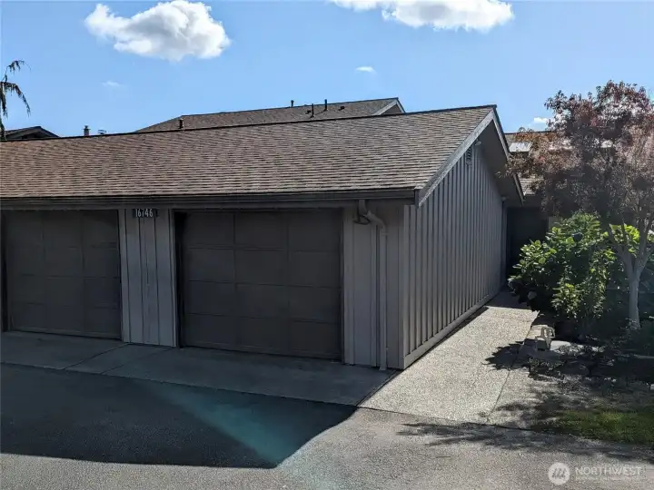 Single car garage and walkway to door.