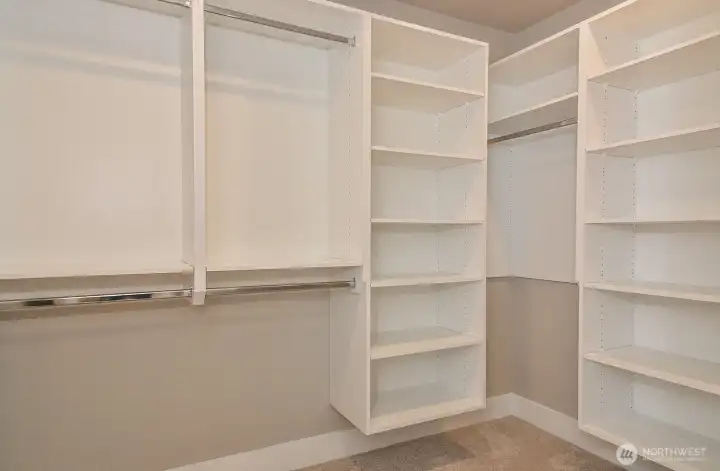 Primary bedrooms's walk-in closet with custom shelving.