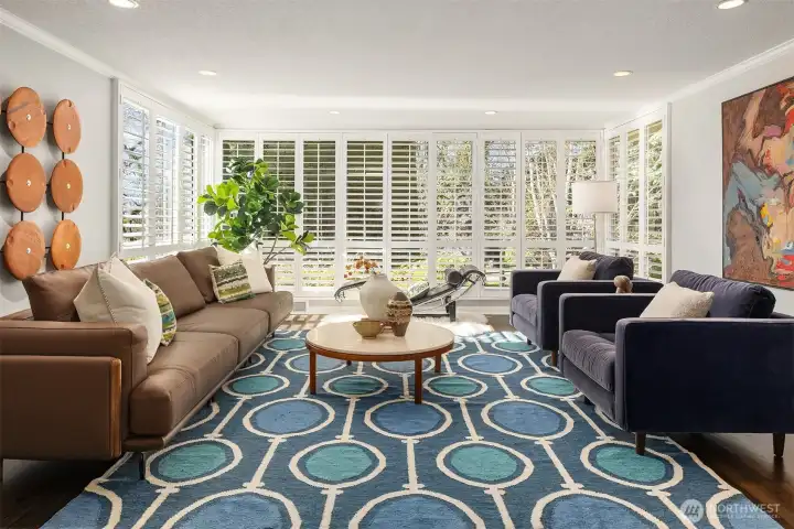 Floor-to-ceiling windows in the living room face north, west, and south; with mature evergreens across the street offering protection from late afternoon summer sun while allowing ample light to filter in throughout the day and throughout the year.