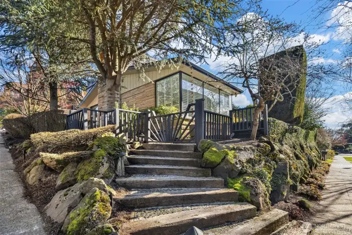 Beautiful fence and entry gate artfully separates the front stairs from the private entry walkway and patio.