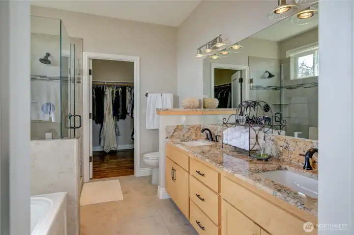 Dual vanity sinks with granite countertops and new fixtures round out the bathroom.