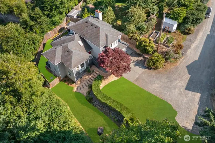 Expansive back yard w/ outdoor kitchen, multiple entertaining areas, Swim Spa & garden beds