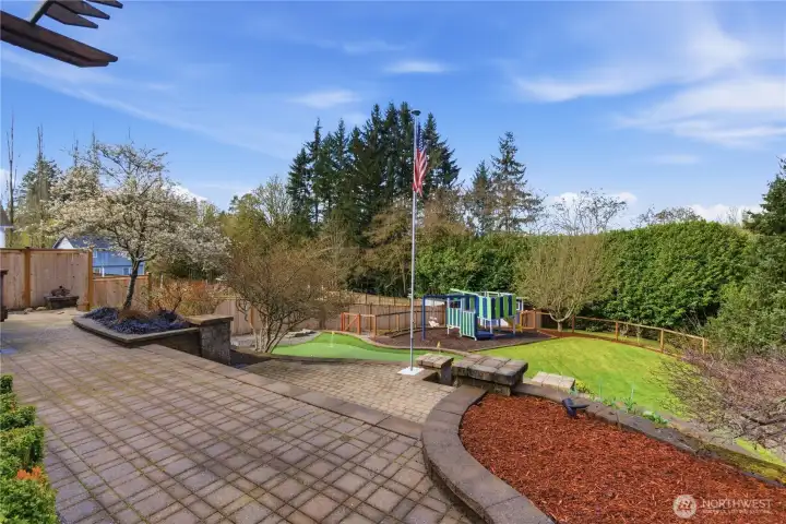 Backyard with a putting green and fenced dog run—ready for fun and play