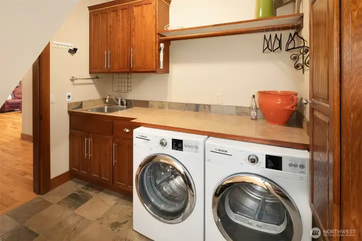 Main floor laundry room with laundry sink and pull down ironing board (not pictured)