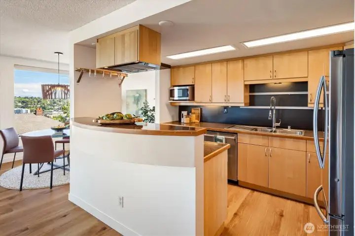 Induction stove and stainless appliances abut the spacious dining area