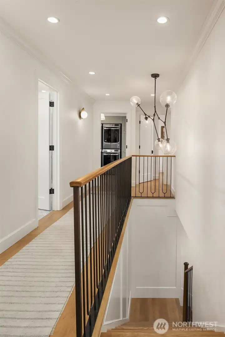 A custom stairway railing & designer chandelier lead the way upstairs. A custom stairway railing & designer chandelier lead the way upstairs.