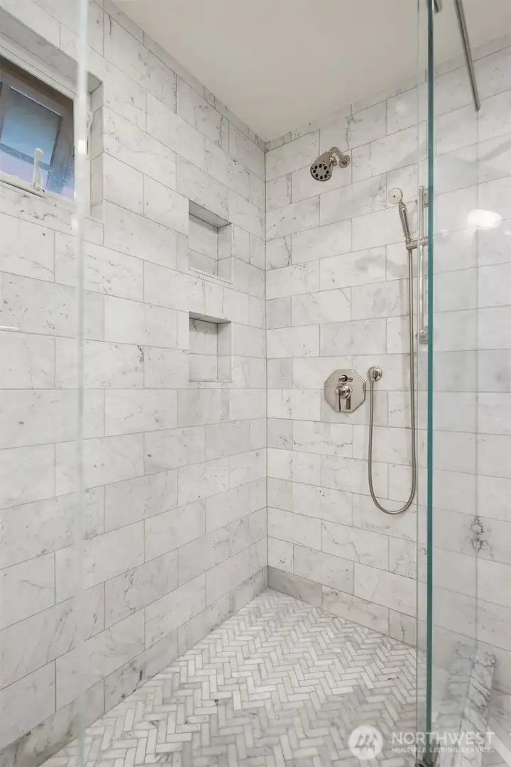 The oversized shower is also dressed in opulent marble tile. The oversized shower is also dressed in opulent marble tile.