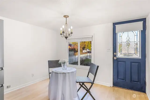 Bright and welcoming, the dining area features a large window overlooking the front yard, allowing for plenty of natural light. The purple front door with decorative glass detailing adds a unique touch, blending character with modern functionality.