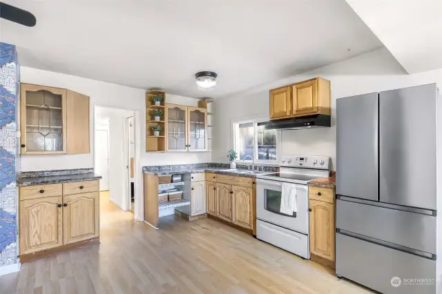 The heart of the home, this bright kitchen offers a thoughtful layout with abundant storage and counter space. Large windows bring in natural light, creating an inviting space for cooking and gathering.