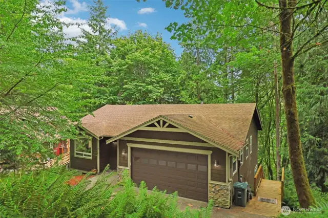 Surrounded by trees, this lovely home offers exterior access to the lower level.