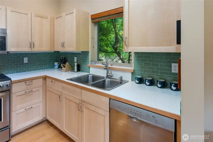 Stainless steel appliances, glass tile backsplash, warm wood cabinets.