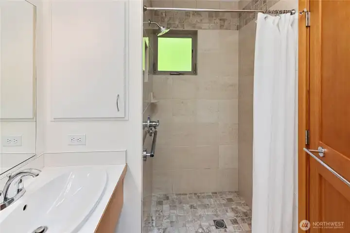 Stylish tiled shower, nice hardware/plumbing.