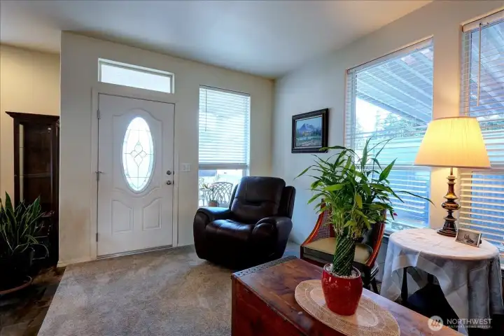 Step inside this bright and welcoming living area, where a large window and a front door with an elegant oval window fill the space with natural light. The open layout seamlessly connects the living room to the entryway, creating a spacious and comfortable feel. This area is perfect for relaxing after a long day or greeting guests.