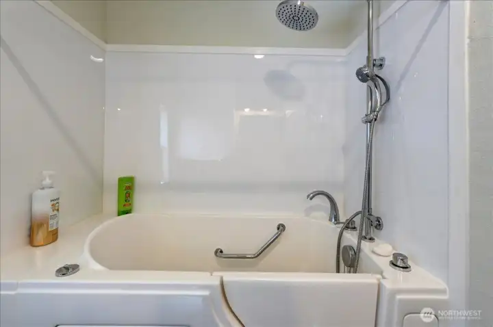 Discover comfort and convenience in this thoughtfully designed bathroom featuring a modern walk-in tub. Perfect for relaxation and accessibility, this tub offers easy entry and includes grab bars for added safety and peace of mind. The sleek, clean design of the shower surround complements the tub, providing a serene and functional space to unwind.