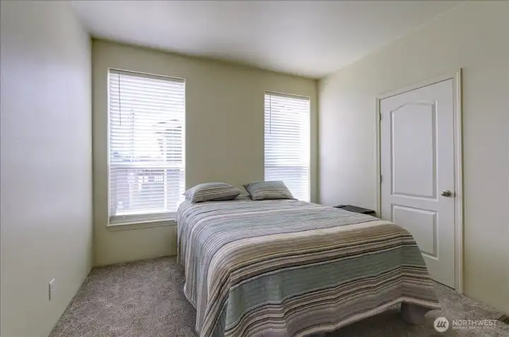 Relax and unwind in this spacious primary suite, designed for comfort and tranquility. The generous room layout easily accommodates a large bed and offers a calm atmosphere for a good night's sleep. Two separate doors lead to a private bathroom and a walk-in closet, providing ample storage and convenience. This is your personal retreat from the everyday.