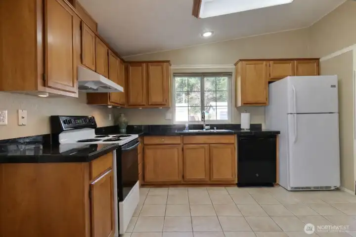 Spacious kitchen with granite tile countertops.