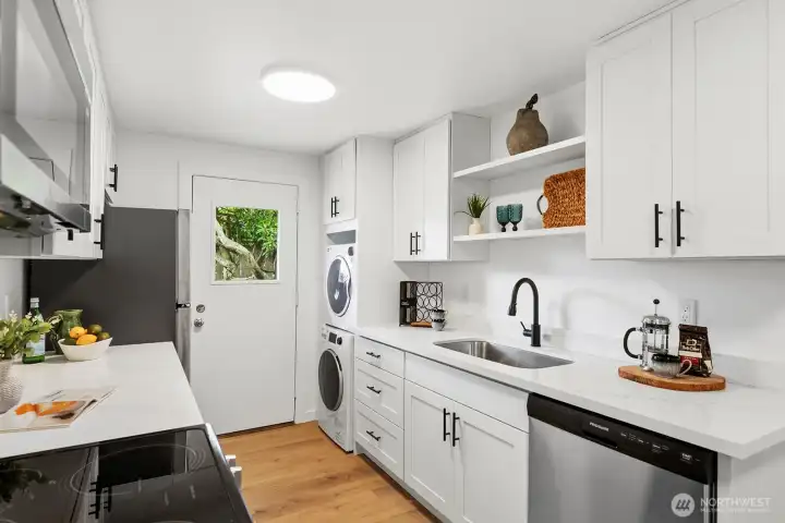 Wowza! Check out this brand new modern kitchen with custom white painted cabinetry, matt black faucet and cabinet pulls, sleek quartz slab counters and all new appliances.