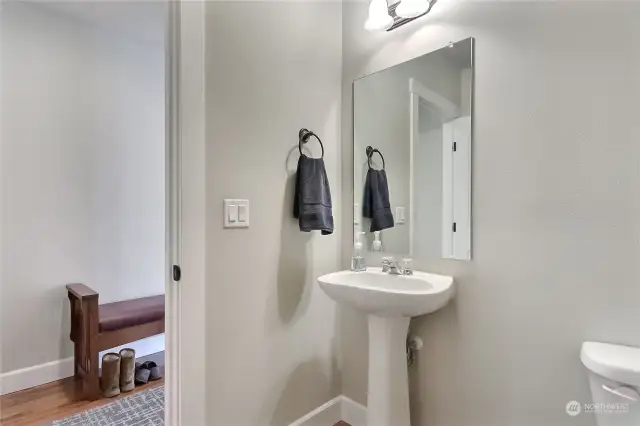 Downstairs half-bath is conveniently located near the second back entrance and mudroom area.