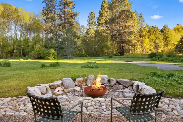 Enjoy sitting by the fire while taking in the beauty of the back yard.