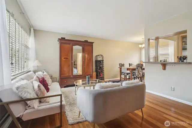 Sunlight pours into the open living & dining space with hardwood floors
