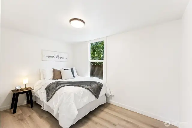 cozy bedroom with natural light and brand new flooring.