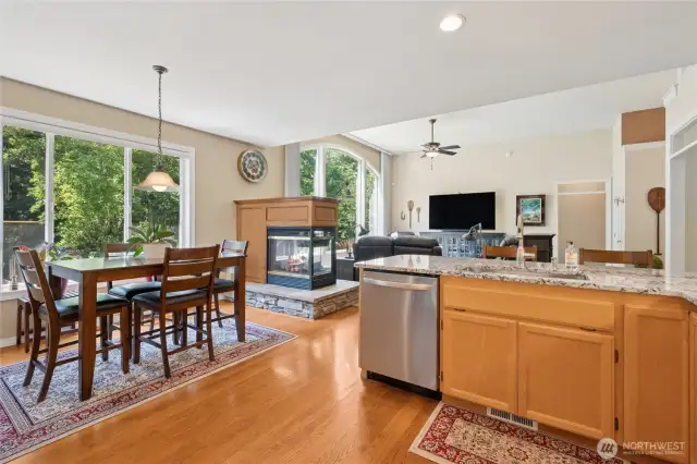 A centrally placed multi-sided fireplace adds cozy ambiance to the kitchen and living areas.