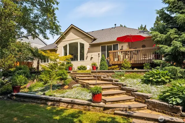 Back of home features graceful stairs connecting each outdoor level.