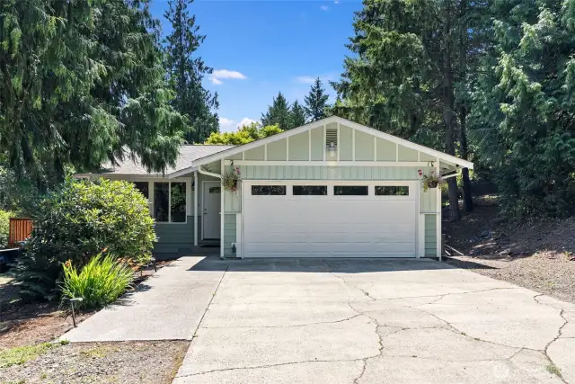 Spacious 2 car garage with level cement driveway with room for basketball hoop,