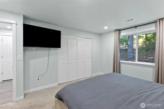 Primary bedroom with neutral colors and nice view to the yard.